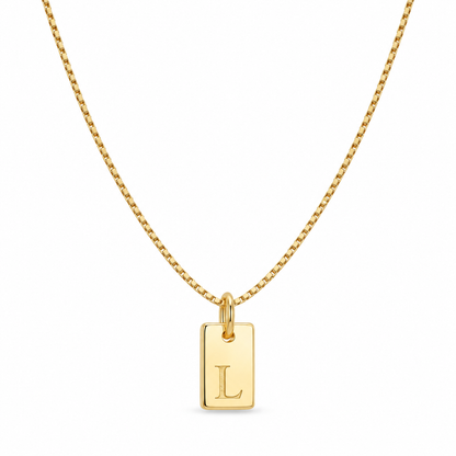 Gold initial tag necklace with a petite letter L pendant and fine box chain on a white background